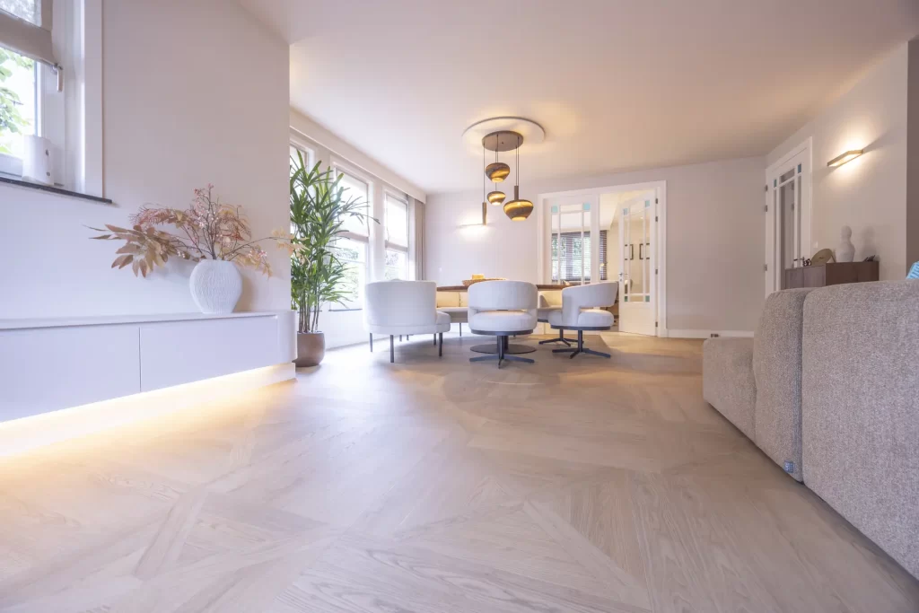 Lange woonkamer met een lichte pvc Hongaarse punt vloer, project Reeshof