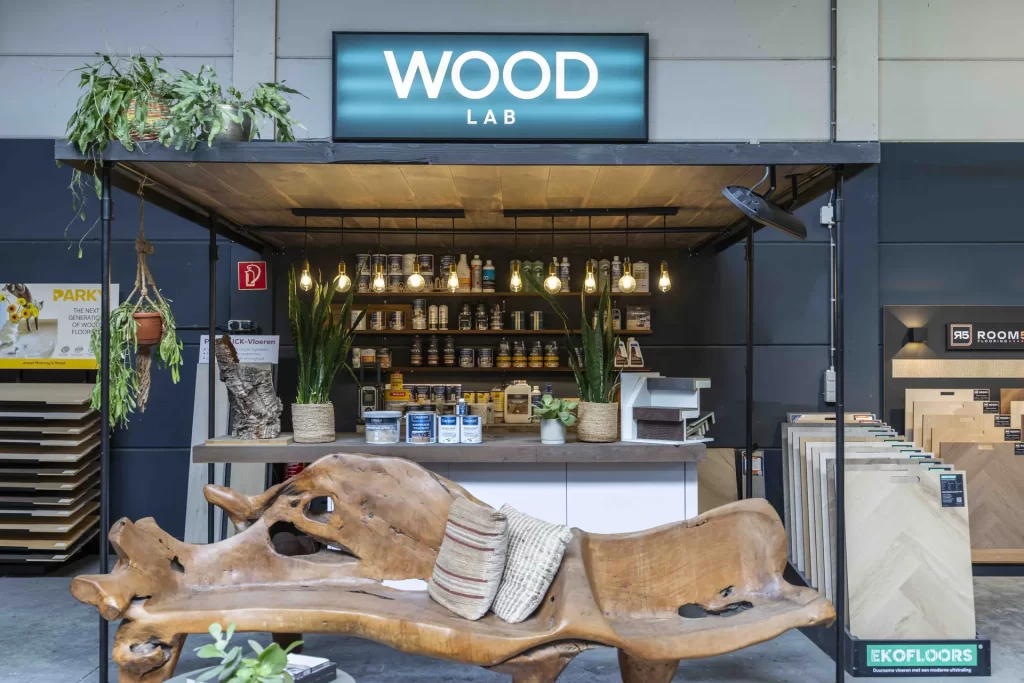 Wood Lab met schappen vol kleur- en afwerkingsproducten en een bank van boomstam